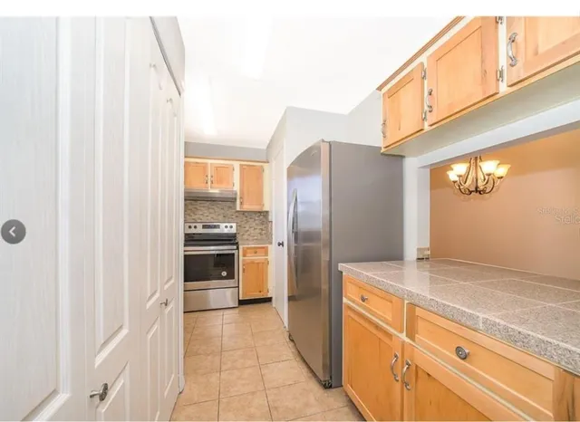 a kitchen with granite countertop a sink and a refrigerator