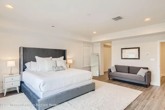 a bedroom with a large bed couch and a window