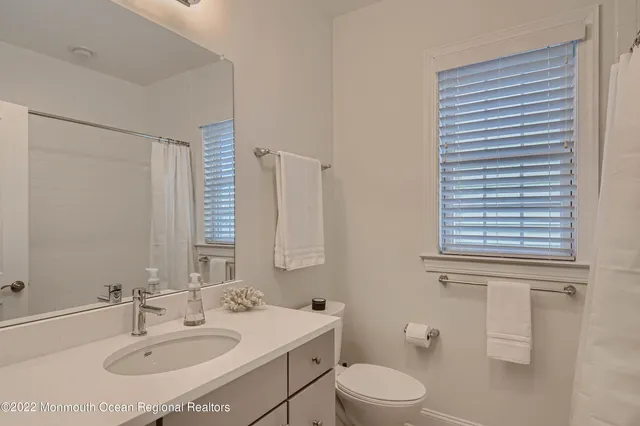 a bathroom with a sink toilet and mirror
