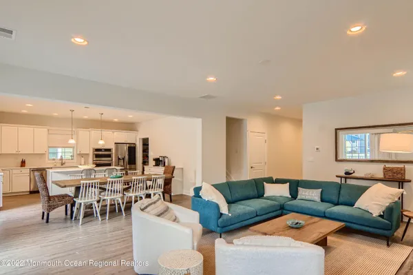 a living room with furniture kitchen view and a large window
