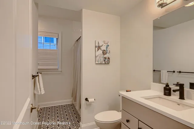 a bathroom with a granite countertop sink a toilet and shower