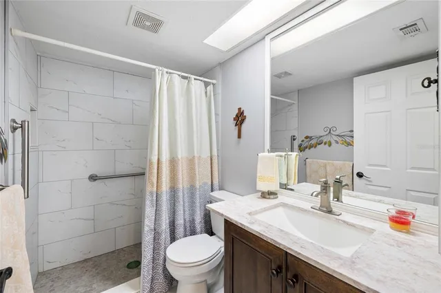 a bathroom with a granite countertop sink toilet and shower