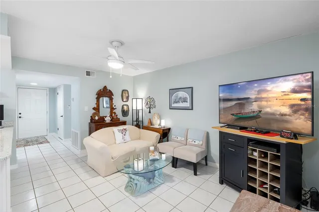 a living room with furniture a flat screen tv and a table