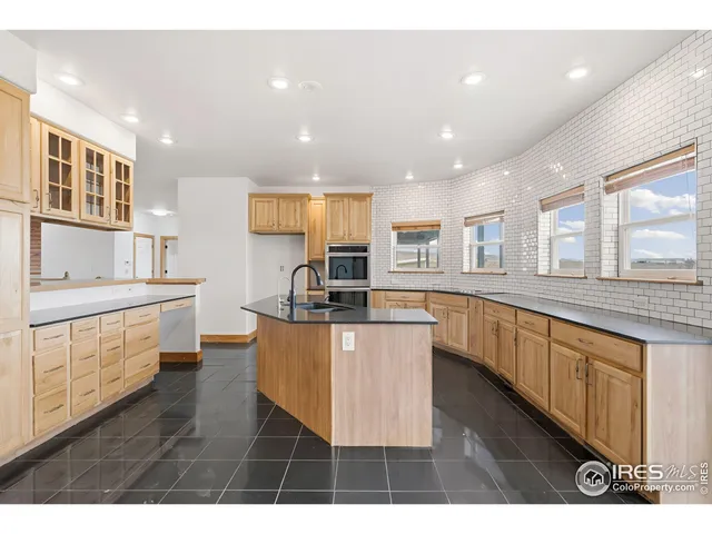 a kitchen with stainless steel appliances kitchen island granite countertop a stove a sink and a refrigerator