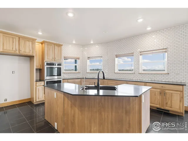 a kitchen with stainless steel appliances granite countertop a sink a stove and a refrigerator