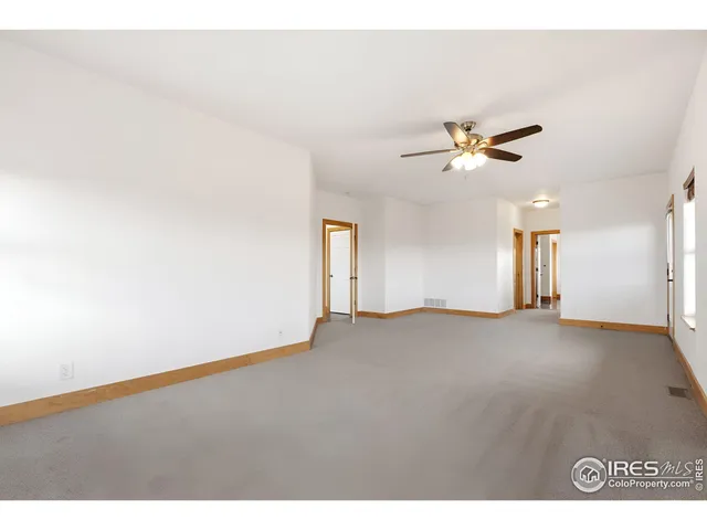 a view of an empty room with a ceiling fan