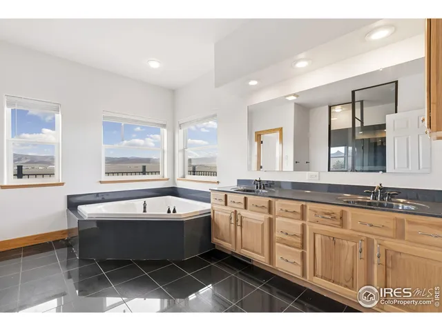 a spacious bathroom with a granite countertop tub sink and mirror