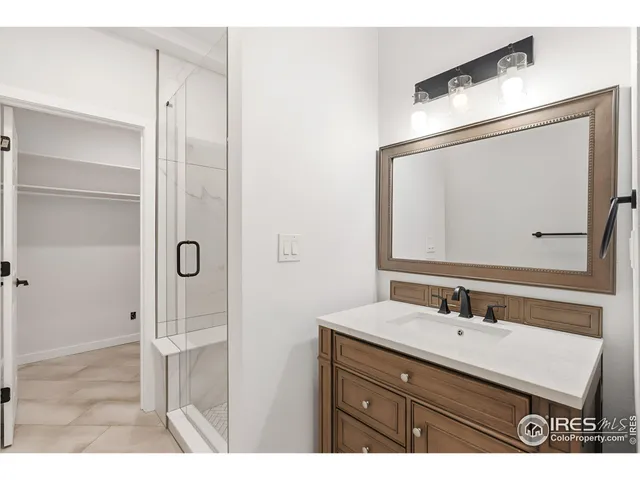a bathroom with a sink vanity granite shower and a mirror