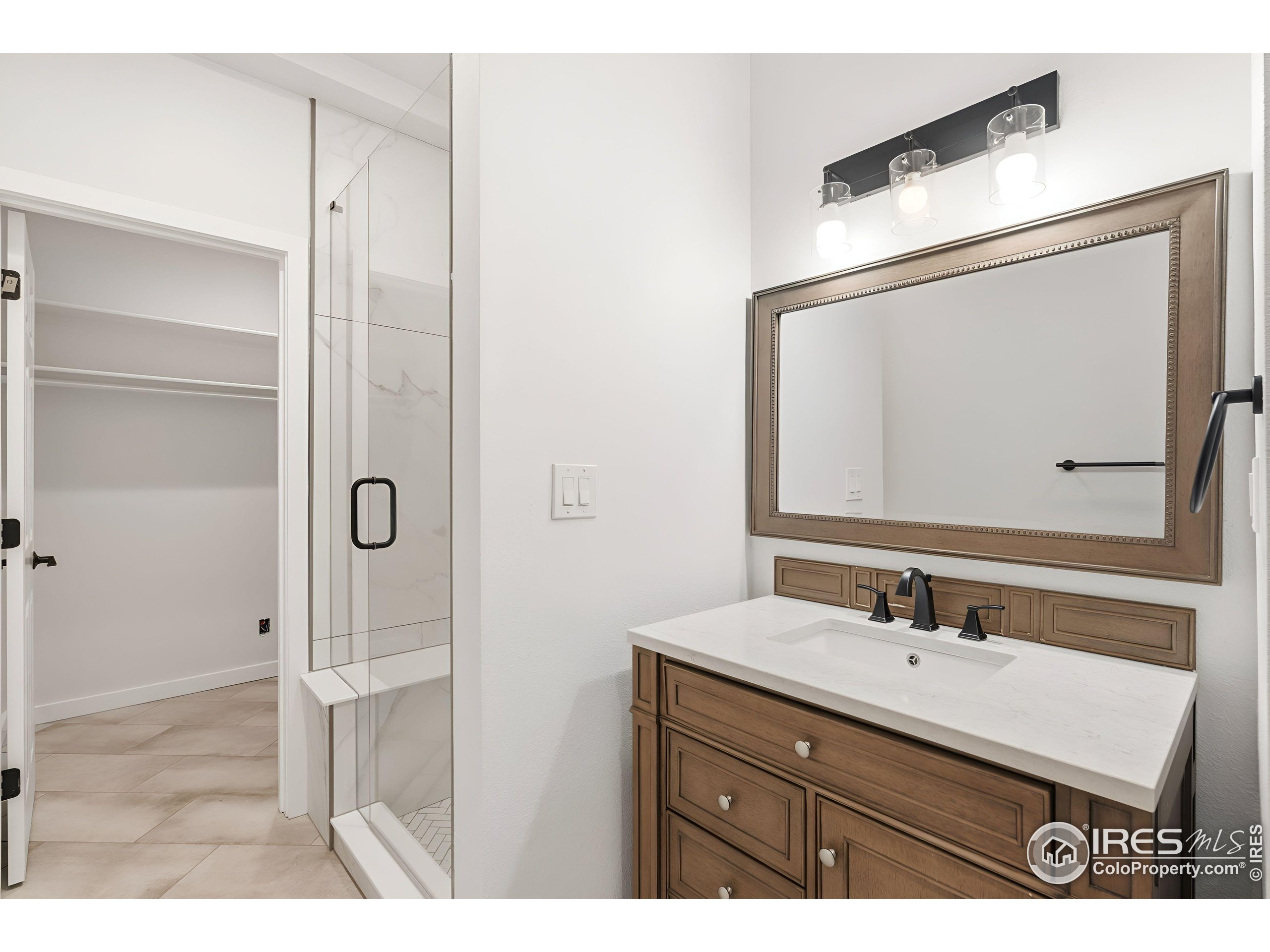 7321 Gilmore Avenue Fort Collins, CO 80524 - Photo 26 of 37 a bathroom with a sink vanity granite shower and a mirror