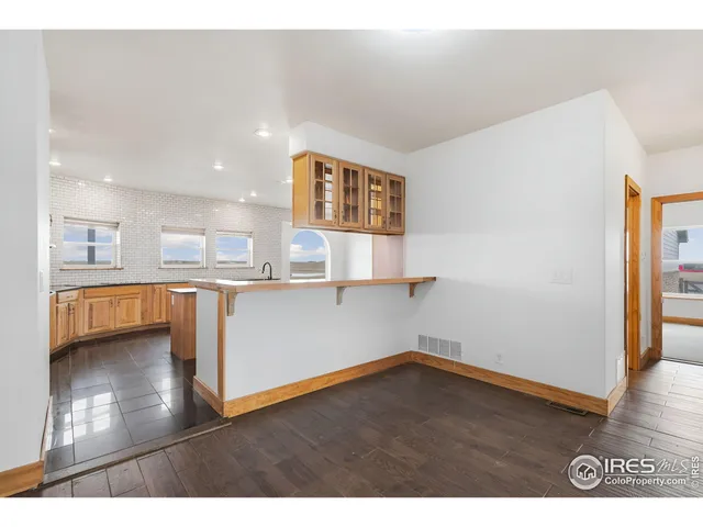 a view of kitchen and hall with wooden floor