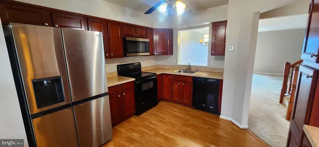 a kitchen with stainless steel appliances granite countertop a refrigerator a stove top oven a sink and dishwasher