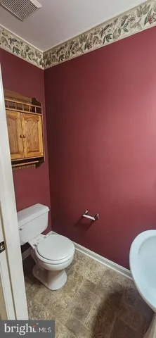 a white toilet sitting next to a bathroom sink and vanity