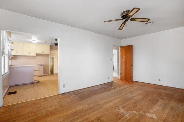 a view of a livingroom with a ceiling fan and kitchen view