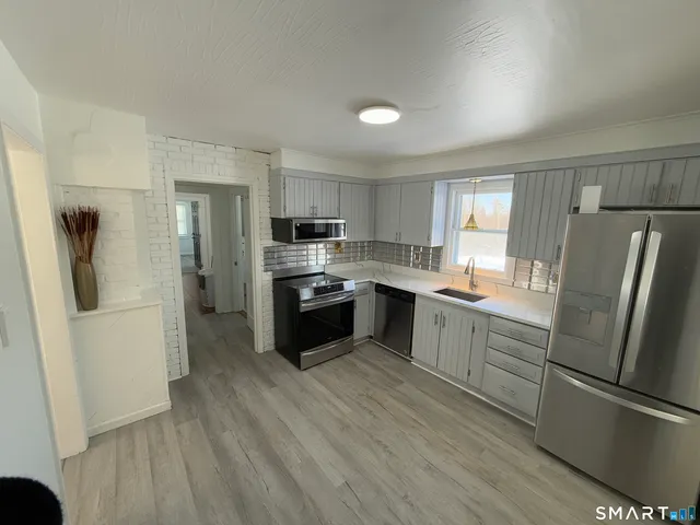 a kitchen with white cabinets and stainless steel appliances