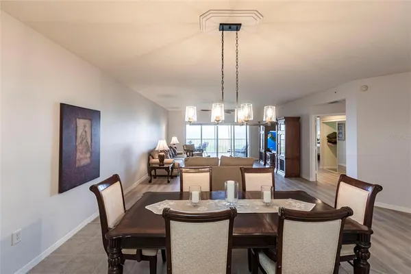 a dining room with furniture a chandelier and wooden floor