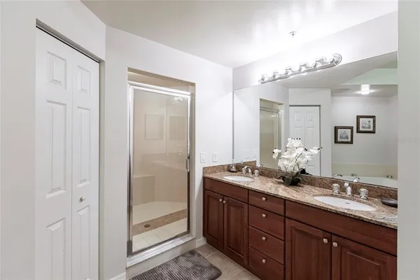 a bathroom with a granite countertop sink a mirror and a shower