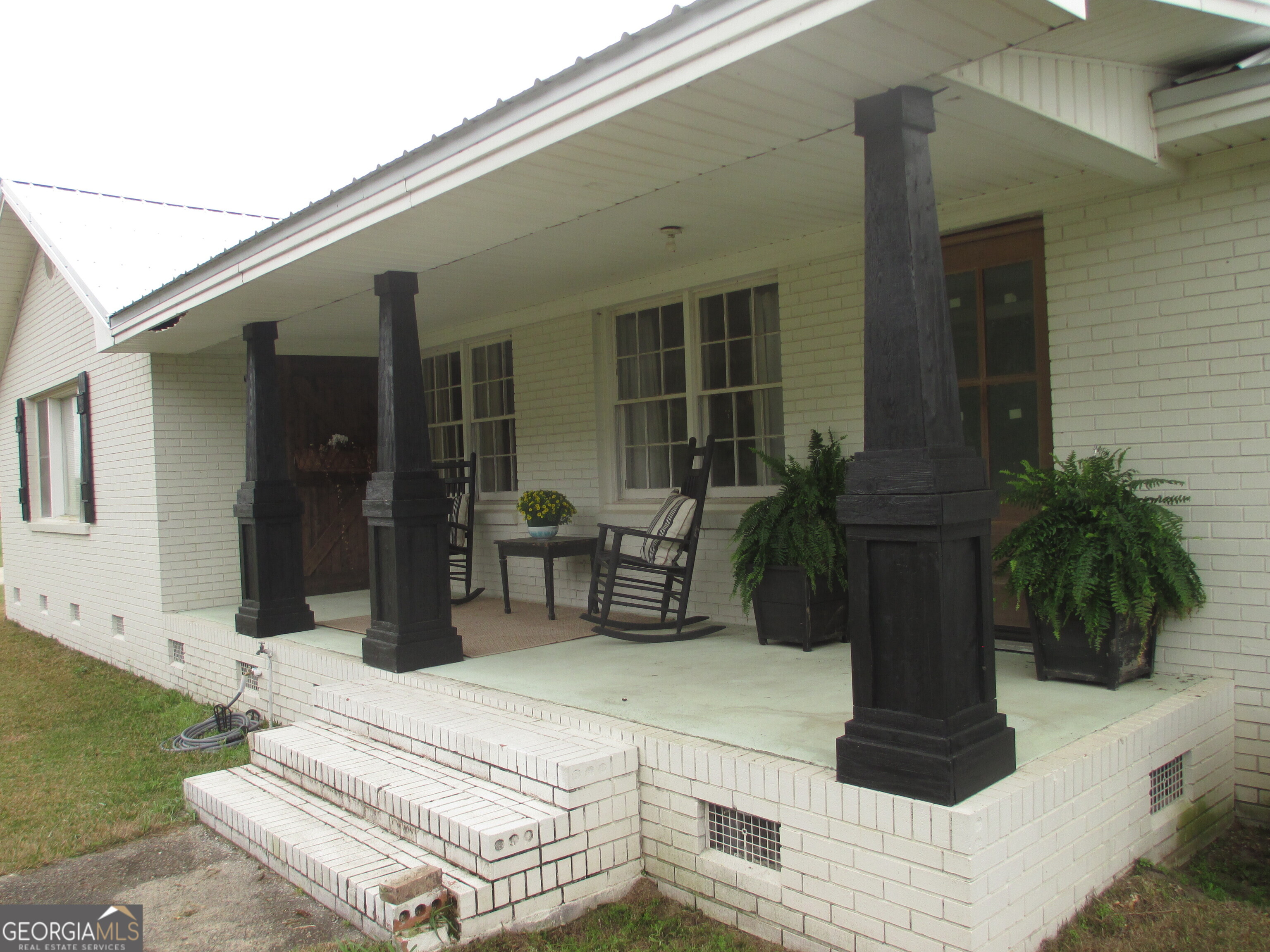 84 Comer Yawn Road Hazlehurst, GA 31539 - Photo 3 of 24 a vase of flowers sitting on a table in front of a house