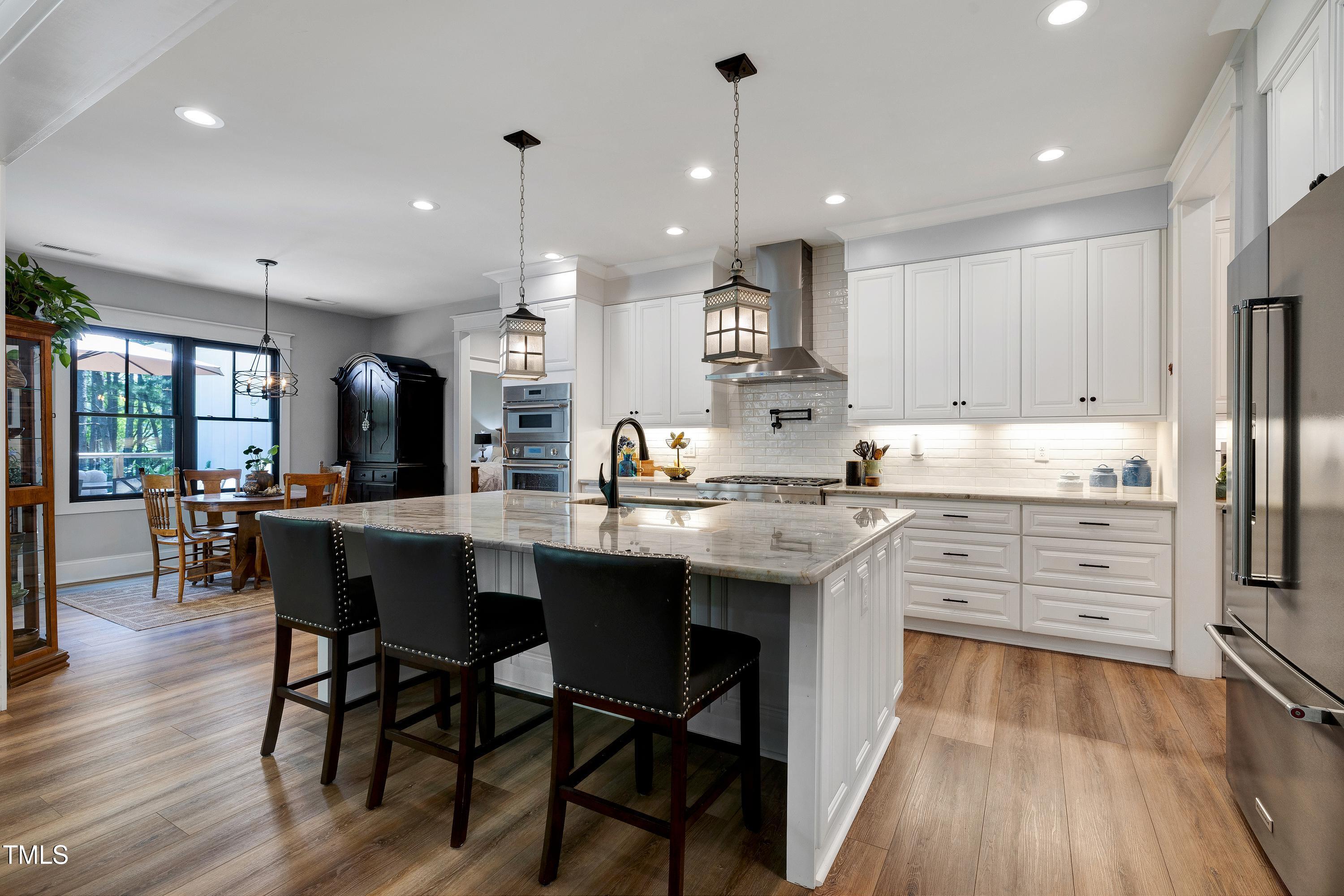5859 Vicksboro Road Henderson, NC 27537 - Photo 23 of 65 a kitchen with stainless steel appliances kitchen island granite countertop a table chairs stove and white cabinets