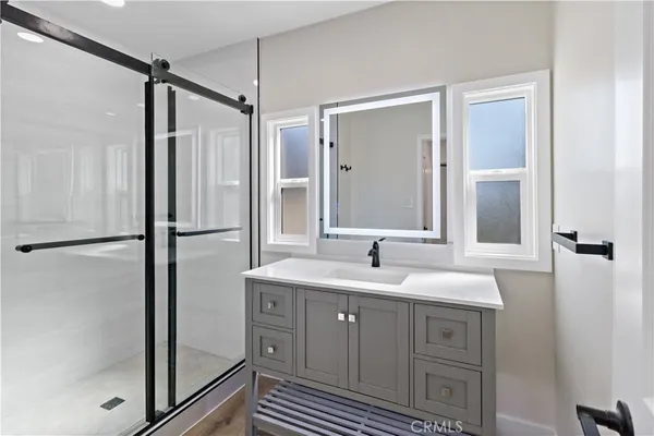 a bathroom with a granite countertop sink mirror and shower