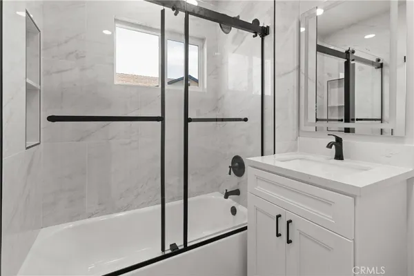 a bathroom with a tub a sink and a shower