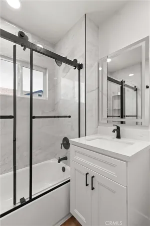 a bathroom with a shower sink and mirror