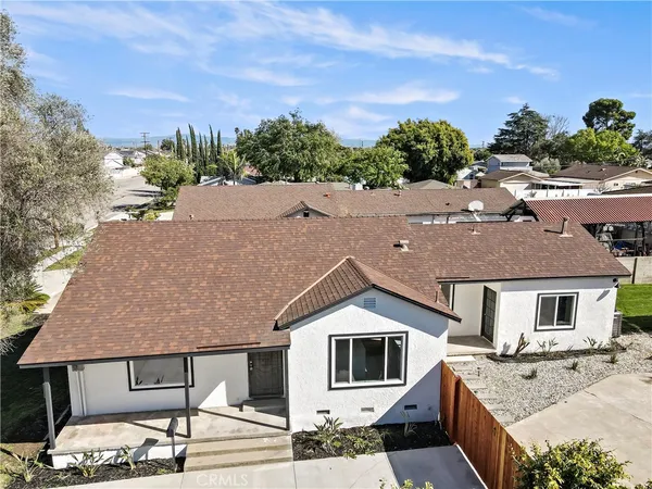 a aerial view of a house with a yard and potted plants