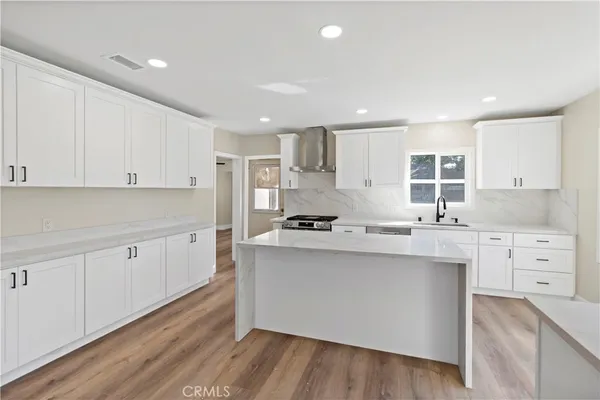 a kitchen with white cabinets sink and stainless steel appliances