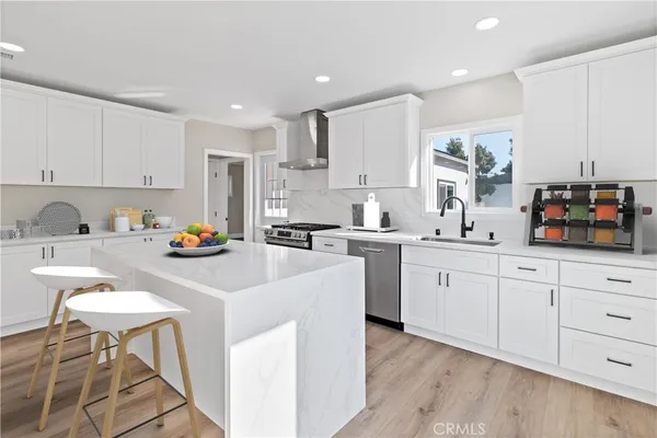 a kitchen with white cabinets and sink