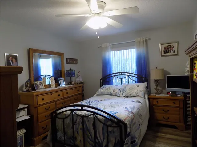 a bedroom with a bed and a flat tv screen on the dresser