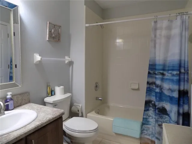 a bathroom with a granite countertop sink toilet a shower and a mirror