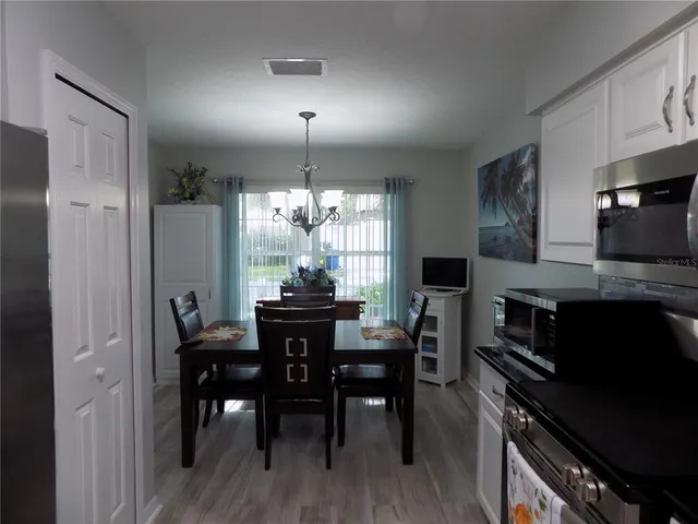 a view of a dining room with furniture a chandelier and wooden floor