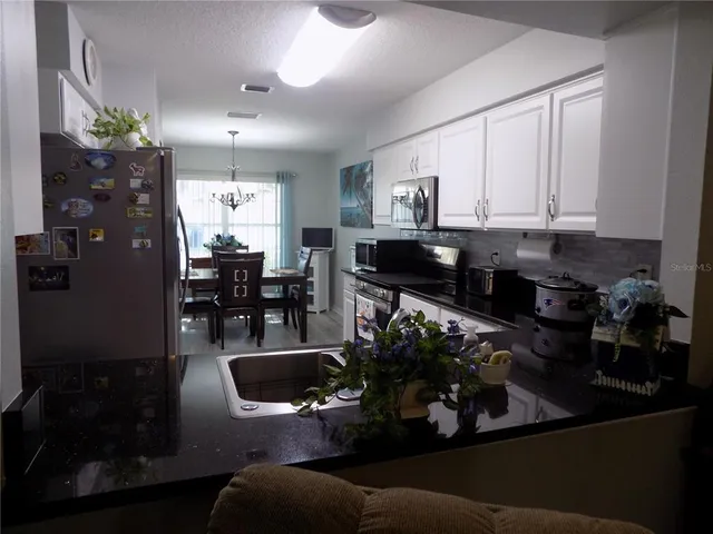 a kitchen with stainless steel appliances a kitchen island sink stove and cabinets