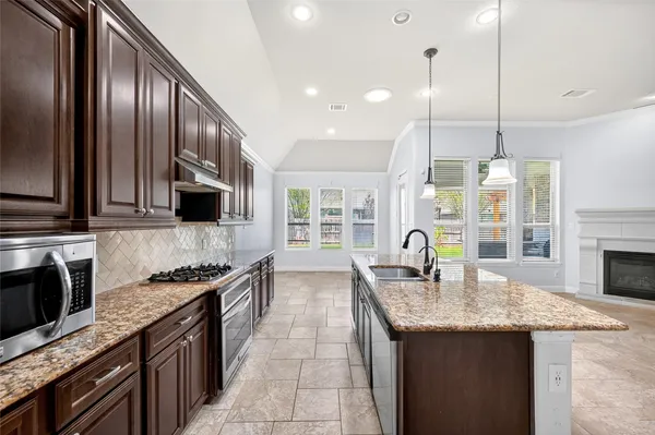 a kitchen with granite countertop stainless steel appliances and wooden cabinets