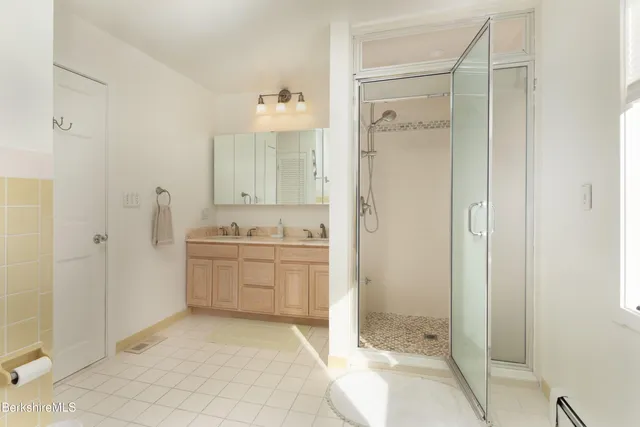 a bathroom with a granite countertop sink a mirror and a shower
