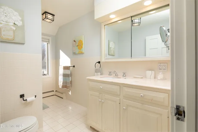 a bathroom with a granite countertop sink mirror and toilet