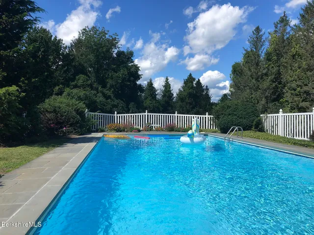 a view of backyard with small cabin and wooden fence