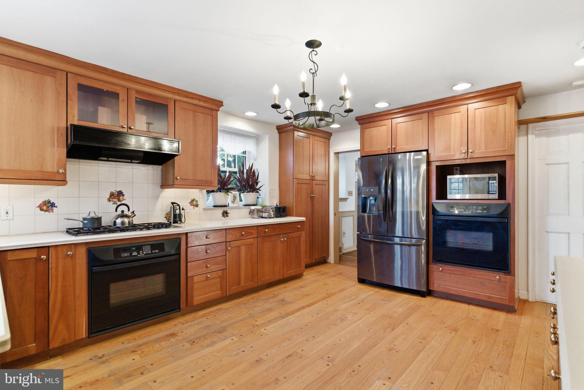 416 Rices Mill Road Wyncote, PA 19095 - Photo 11 of 60 a kitchen with stainless steel appliances granite countertop a refrigerator a sink dishwasher a stove with wooden cabinets and floor