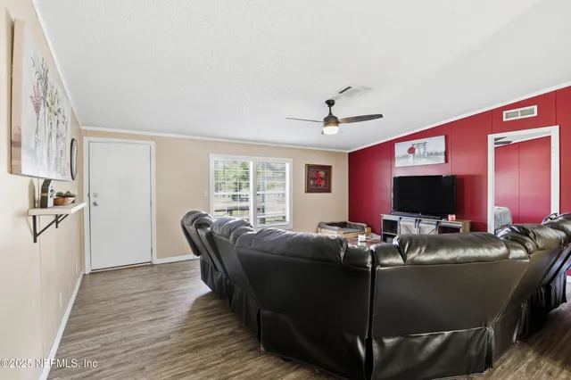 a living room with furniture and wooden floor