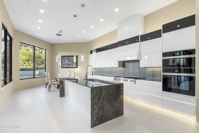 a dining room with furniture and large windows