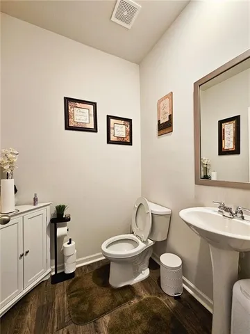 a kitchen with stainless steel appliances granite countertop a refrigerator a stove a sink dishwasher a dining table and chairs with wooden floor