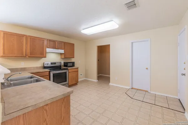 a kitchen with a sink a counter top space cabinets and stainless steel appliances