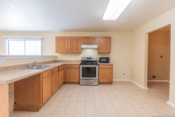 a kitchen with a stove top oven sink and cabinets