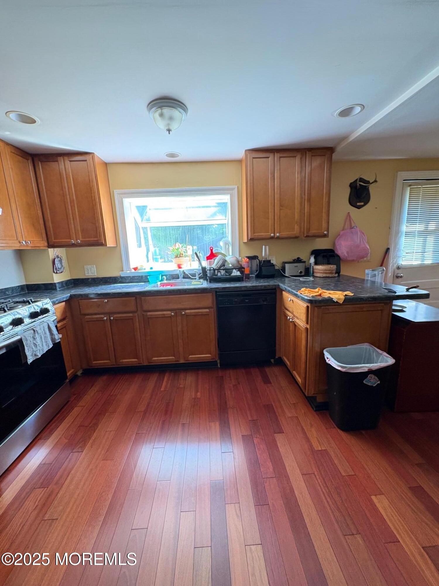 80 Jackson Street Freehold, NJ 07728 - Photo 5 of 21 a kitchen with wooden floors and black stainless steel appliances