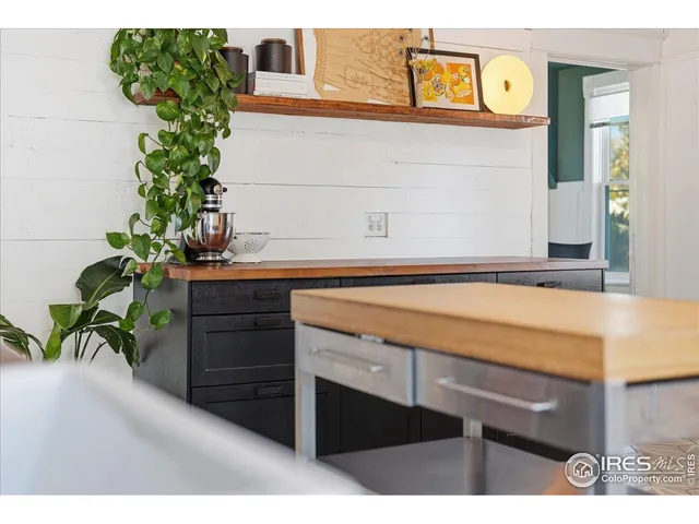 a bedroom with a bed and a dresser next to a window