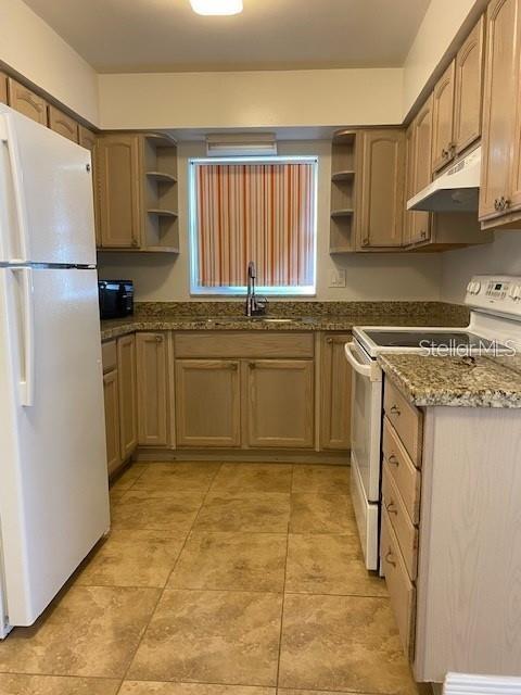 4565 Duhme Road, Unit 110 St. Petersburg, FL 33708 - Photo 6 of 13 a kitchen with stainless steel appliances granite countertop a stove a sink and a refrigerator