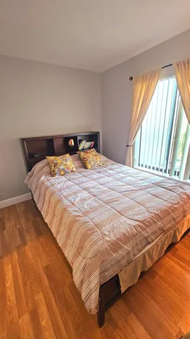 a bed sitting in a bedroom next to a window