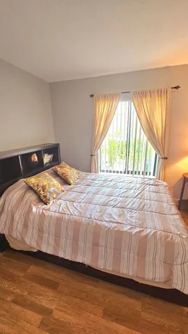 a bedroom with a bed and a large window