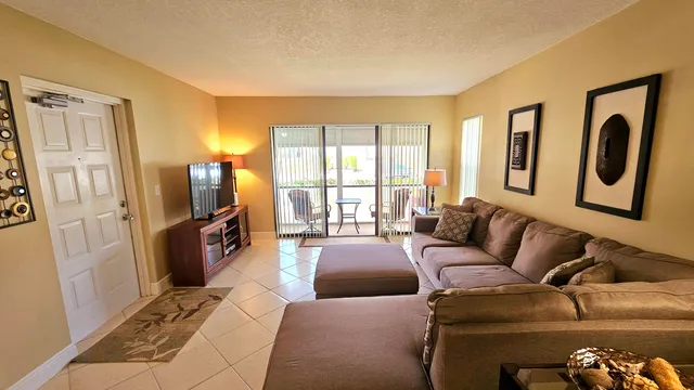 a living room with furniture large window and a flat screen tv