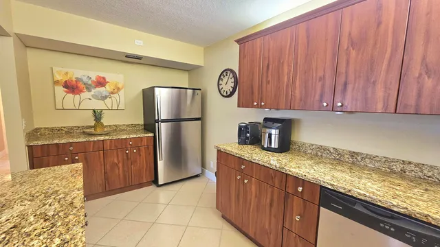 a kitchen with stainless steel appliances granite countertop a refrigerator and a stove top oven