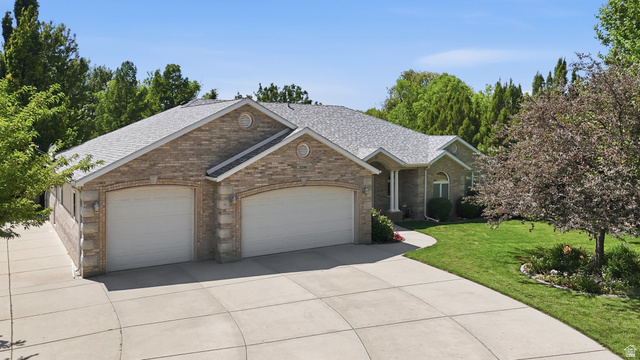 2190 750 West Perry, UT 84302 - Photo 3 of 42 Spacious brick exterior home featuring a two-car garage, concrete driveway, and a manicured lawn